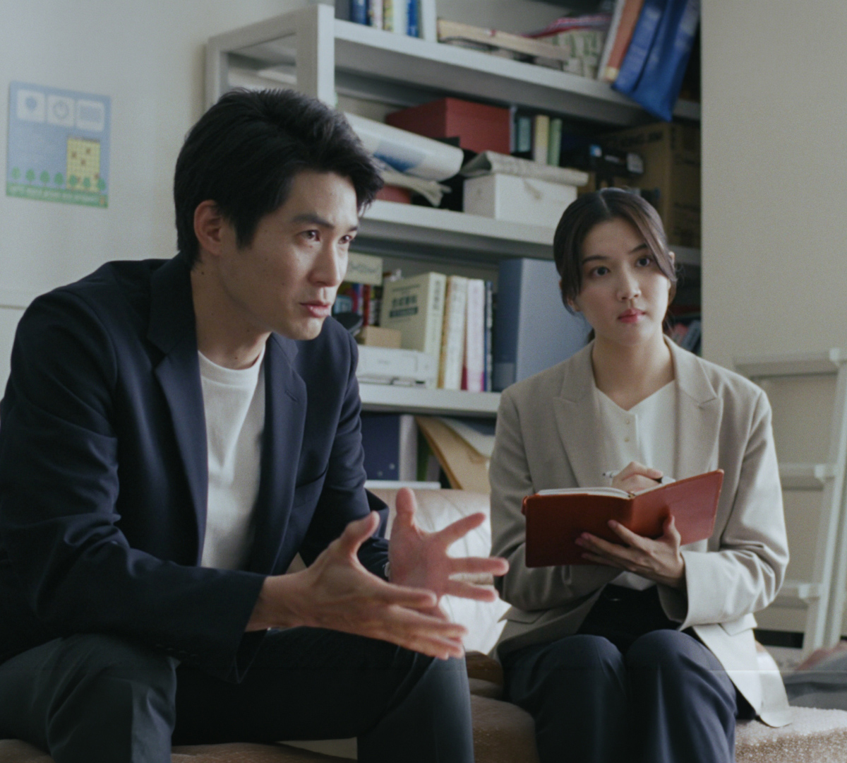 会話する男性とメモを取る女性